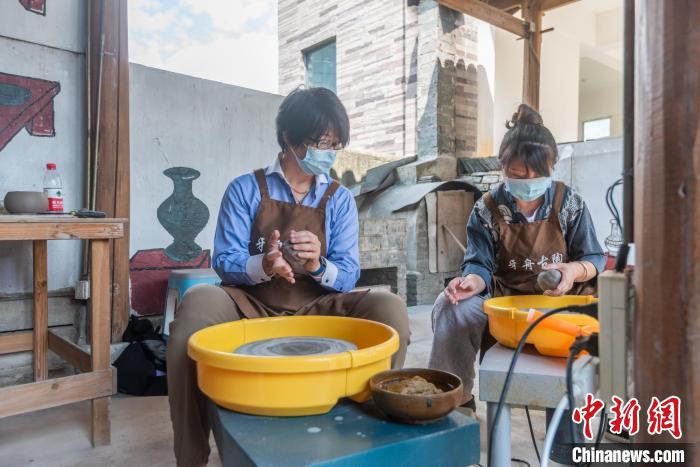 圖為日本駐重慶總領(lǐng)事高田真里體驗(yàn)平塘牙舟陶?！√普?攝