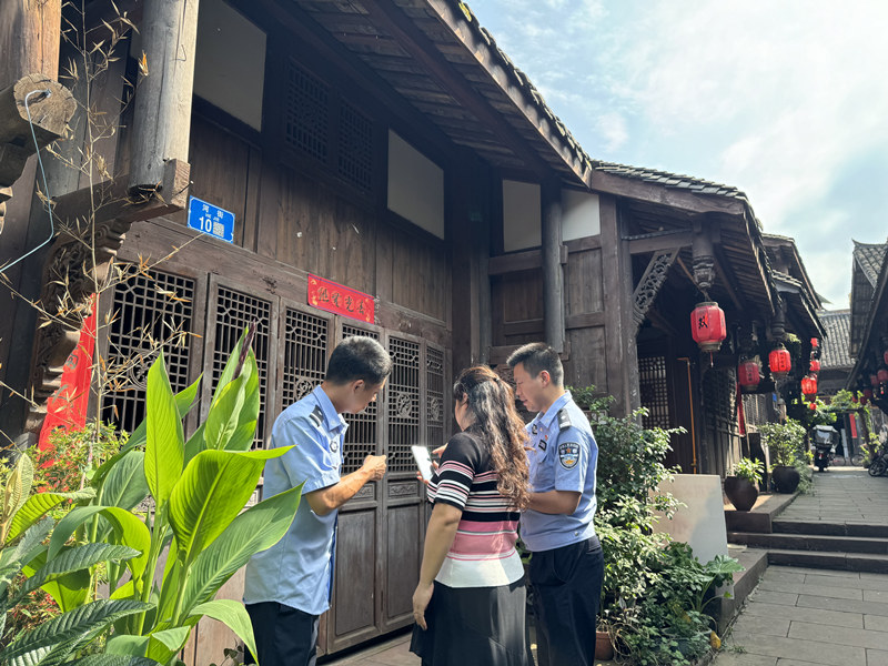 潼南雙江古鎮(zhèn)社區(qū)民警指導(dǎo)群眾掃碼應(yīng)用。潼南區(qū)公安局供圖