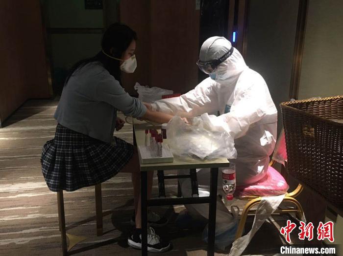 圖為醫(yī)護(hù)工作者正在為歸國(guó)人員進(jìn)行檢測(cè)。西安中醫(yī)腦病醫(yī)院 供圖