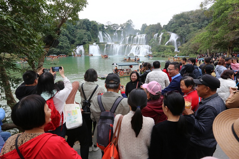在德天跨國瀑布面前,岸線觀景游人如織。梁婷攝