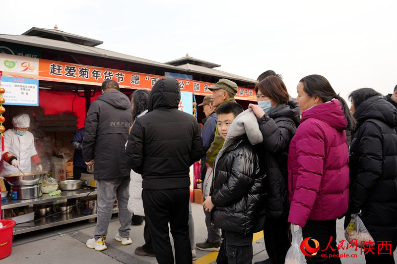 第二屆中歐班列年貨節(jié)的現(xiàn)場,市民排隊品嘗臊子面。人民網(wǎng)記者 賈凱璐攝