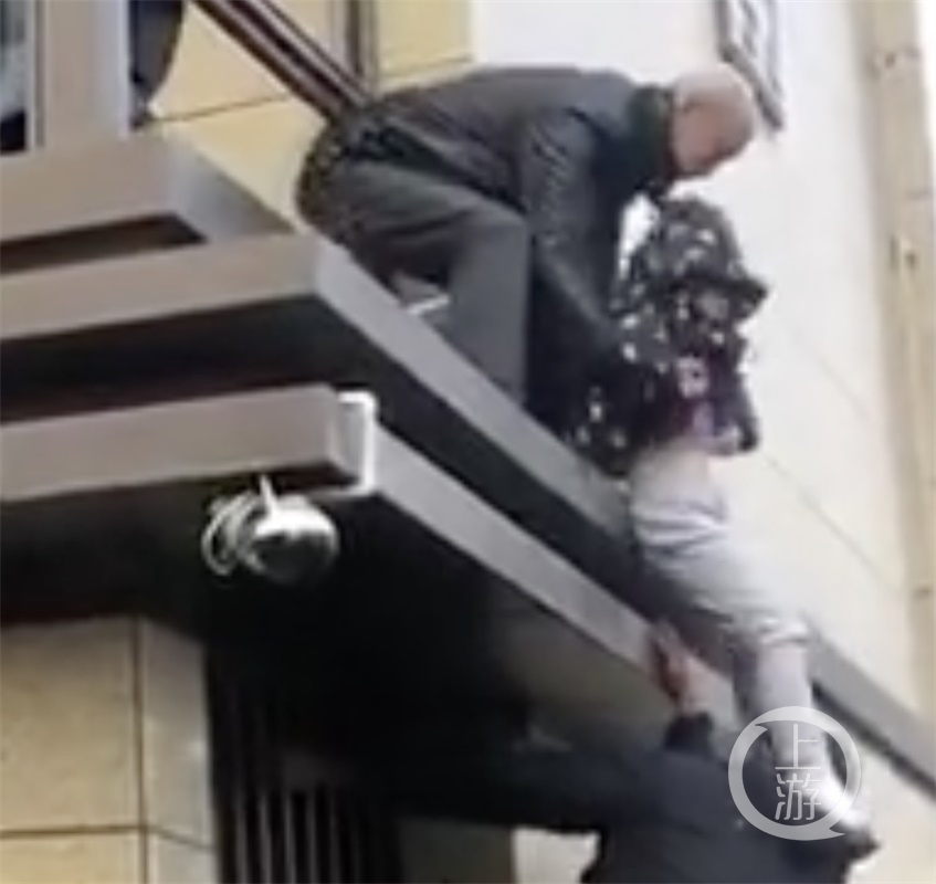 ▲在執(zhí)法過程中，業(yè)主用孩子踢打執(zhí)法人員，試圖阻止拆除違建。圖片來源/視頻截圖